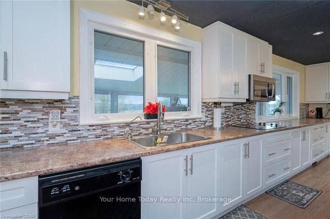 Kitchen featuring black appliances, white cabinets, sink, and a wealth of natural light | Image 15