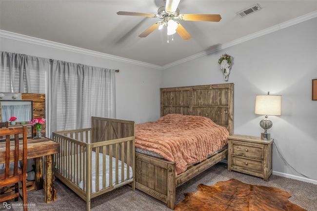 Bedroom with baseboards, visible vents, ornamental molding, and carpet flooring | Image 25