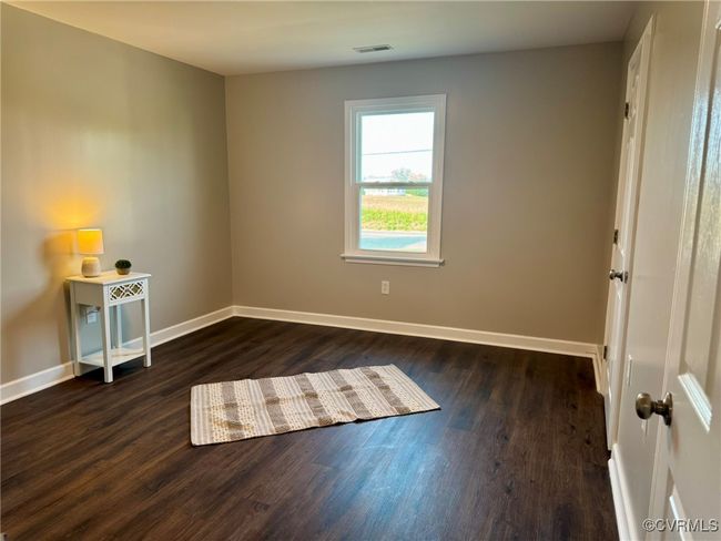 Spare room with dark wood-style flooring and baseboards | Image 16