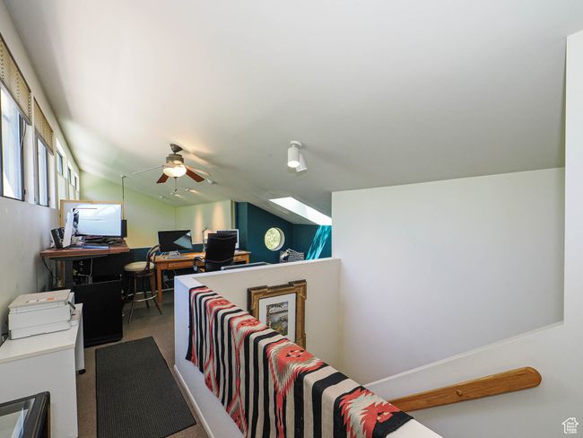 Office space featuring a ceiling fan, carpet flooring, and vaulted ceiling | Image 43