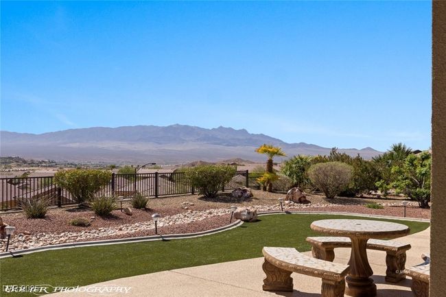 View of home's community with a yard, a mountain view, fence, and a patio | Image 63