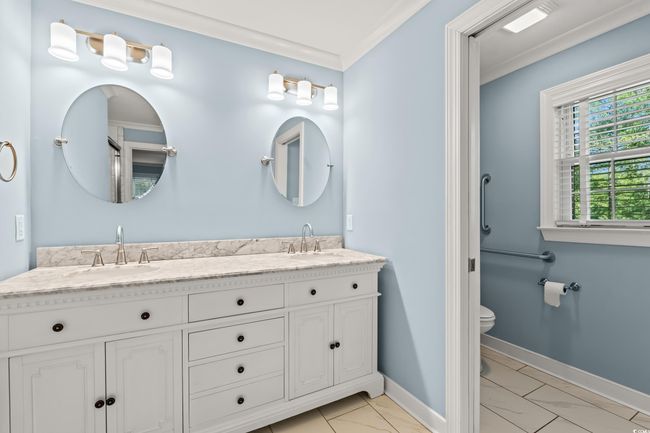 Full bath with ornamental molding, double vanity, and marble finish flooring | Image 13