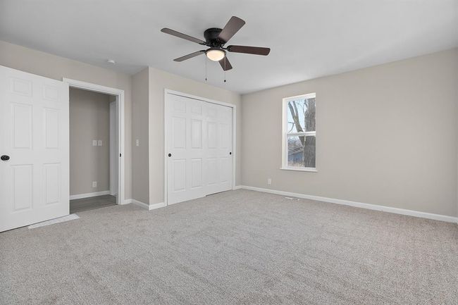 Unfurnished bedroom featuring carpet floors, baseboards, a closet, and ceiling fan | Image 12