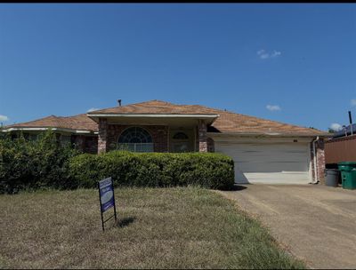 Ranch-style home with a garage and a front lawn | Image 2