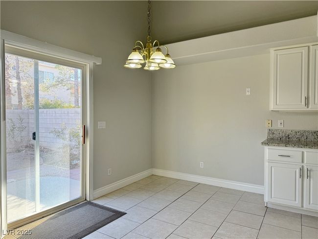 Unfurnished dining area featuring a chandelier, light tile patterned floors, and baseboards | Image 16