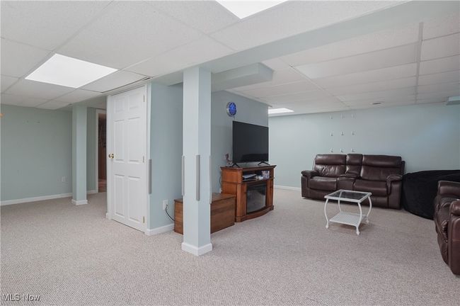 Living area with a paneled ceiling, carpet flooring, and baseboards | Image 38