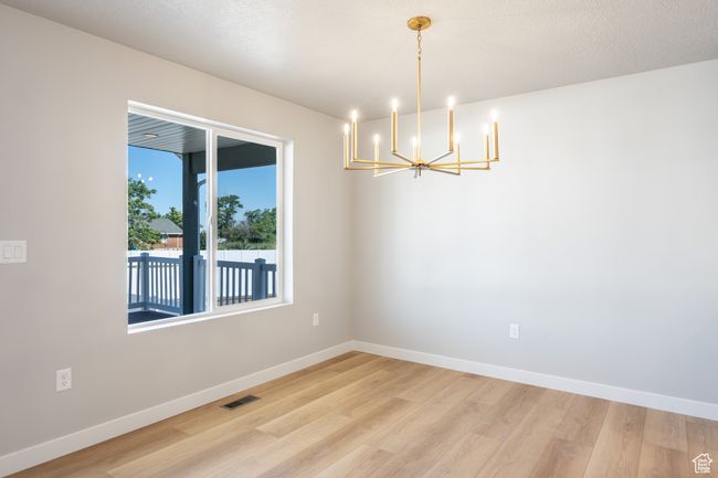 Unfurnished room featuring a chandelier and light wood-style flooring | Image 11
