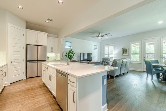Kitchen with appliances with stainless steel finishes, a sink, a ceiling fan, light countertops, and light wood finished floors | Image 11