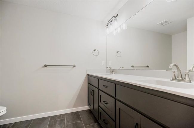 Bathroom featuring double vanity, toilet, and baseboards | Image 18