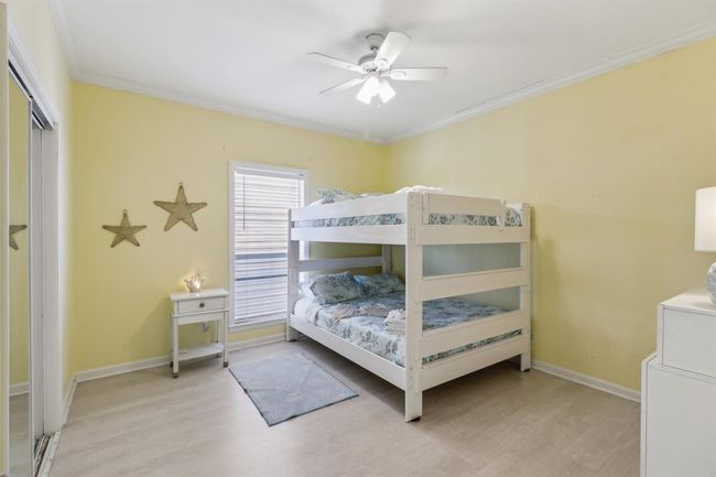This bright and cheerful secondary bedroom features soft yellow walls that create a warm and inviting atmosphere. A large window allows natural light to fill the space, highlighting the clean lines of the room and its simple design. The mirrored closet doors enhance the sense of space while providing convenient storage. This cozy retreat is perfect for guests or family members to relax and enjoy. | Image 9