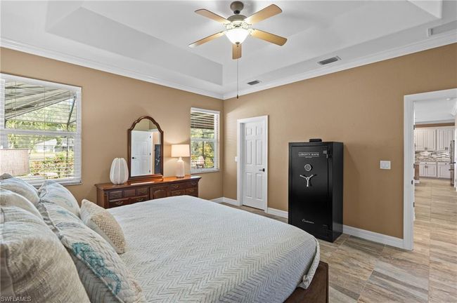 Bedroom featuring a raised ceiling, ornamental molding, a ceiling fan, and baseboards | Image 26