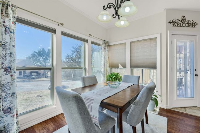 Dining area featuring a chandelier, crown molding, and wood finished floors | Image 15
