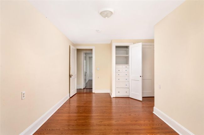 Unfurnished bedroom featuring baseboards, wood finished floors, and a closet | Image 11