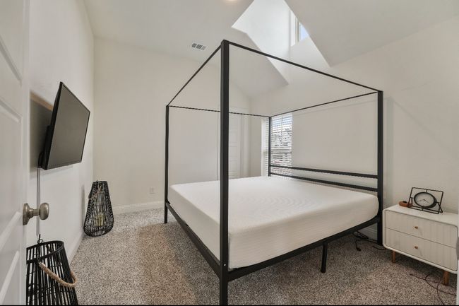 Bedroom with carpet, baseboards, and lofted ceiling | Image 16