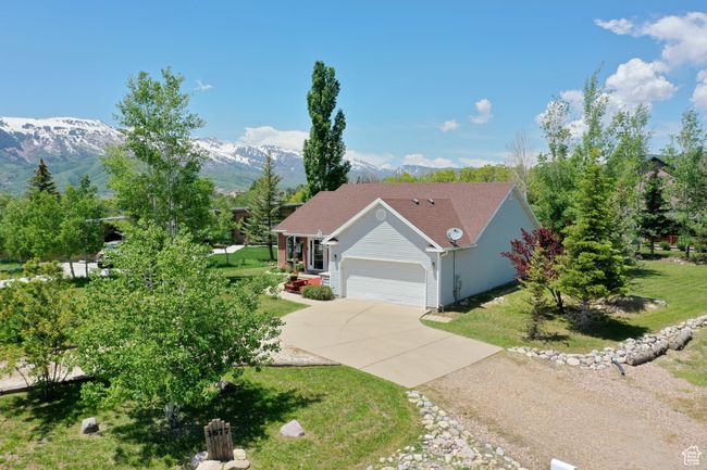 Ranch-style home with concrete driveway, an attached garage, a mountain view, and a front lawn | Image 42
