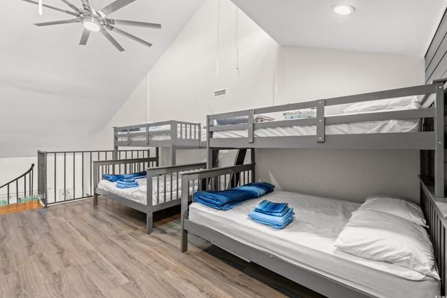 Bedroom featuring wood finished floors and high vaulted ceiling | Image 23
