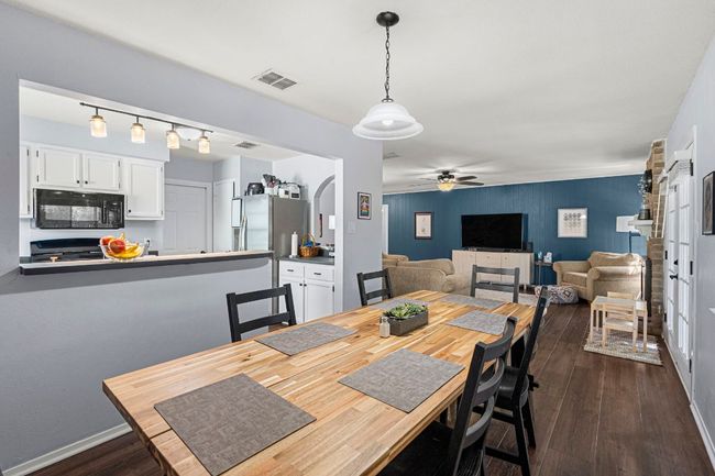 Dining space with ceiling fan, dark wood-type flooring, and baseboards | Image 12