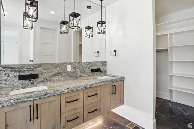 Bathroom with marble finish flooring, double vanity, recessed lighting, a walk in closet, and decorative backsplash | Image 32