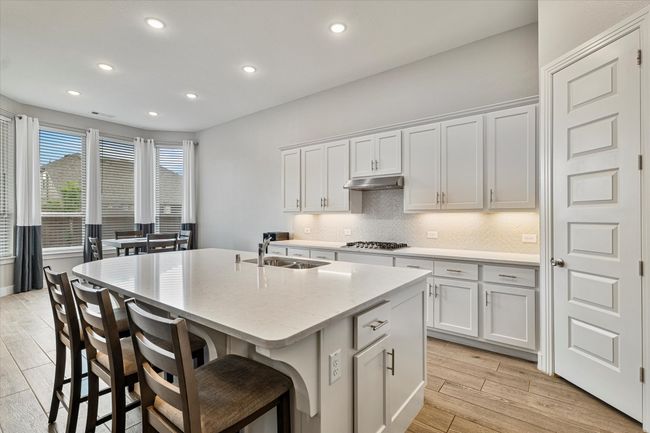 Kitchen with a sink, a center island with sink, recessed lighting, and light wood-style flooring | Image 7