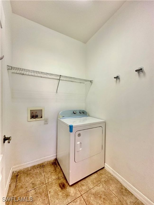 Clothes washing area with washer / clothes dryer and light tile patterned flooring | Image 11