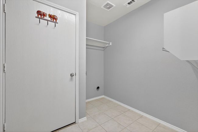 Utility room with light tile patterned flooring and baseboards | Image 11