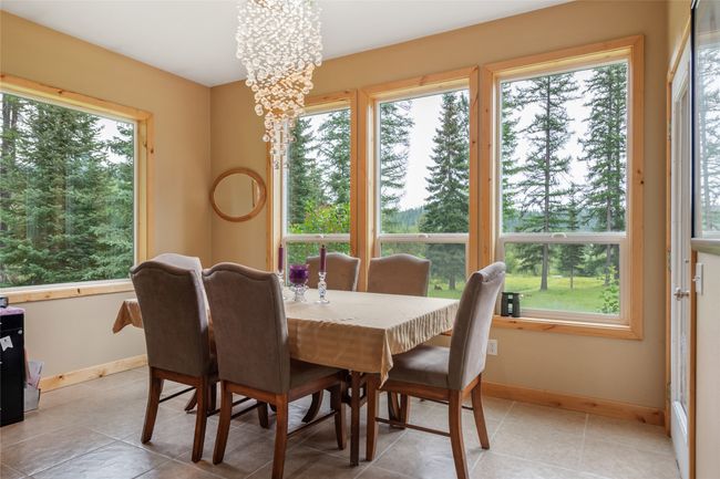 Dining room with plenty of natural light, a chandelier, and light tile patterned floors | Image 39