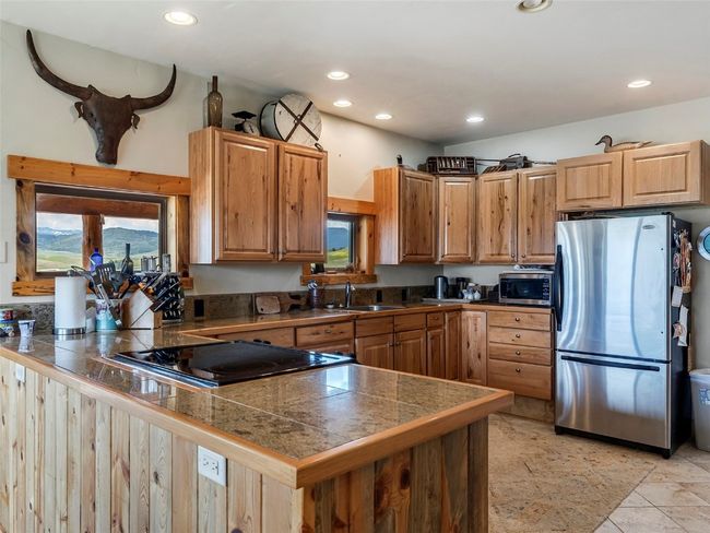 Kitchen with sink, light tile patterned floors, and stainless steel appliances | Image 21