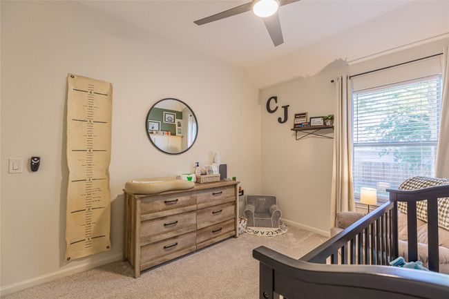 Bedroom featuring light carpet, a nursery area, baseboards, a ceiling fan, and lofted ceiling | Image 23