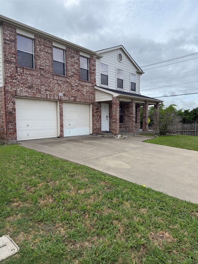 View of front facade featuring concrete driveway, brick siding, and a garage | Image 27