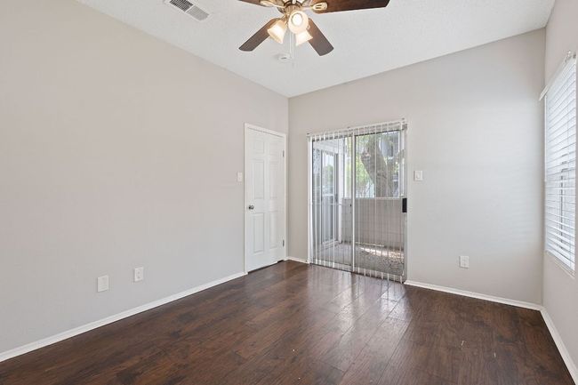 Unfurnished room with baseboards, a ceiling fan, visible vents, and wood finished floors | Image 14