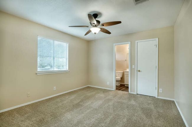 Unfurnished bedroom with carpet floors, baseboards, and connected bathroom | Image 6