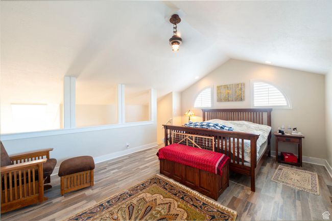 Bedroom with wood finished floors, baseboards, and vaulted ceiling | Image 25