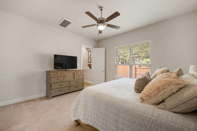 Bedroom featuring baseboards, light colored carpet, and ceiling fan | Image 14