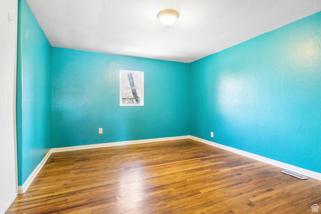 Spare room featuring wood finished floors, baseboards, and visible vents | Image 37