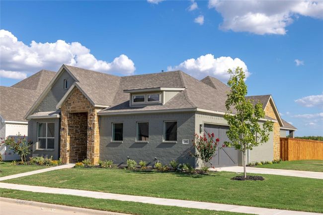 View of front facade with concrete driveway, a garage, brick siding, and roof with shingles | Image 30