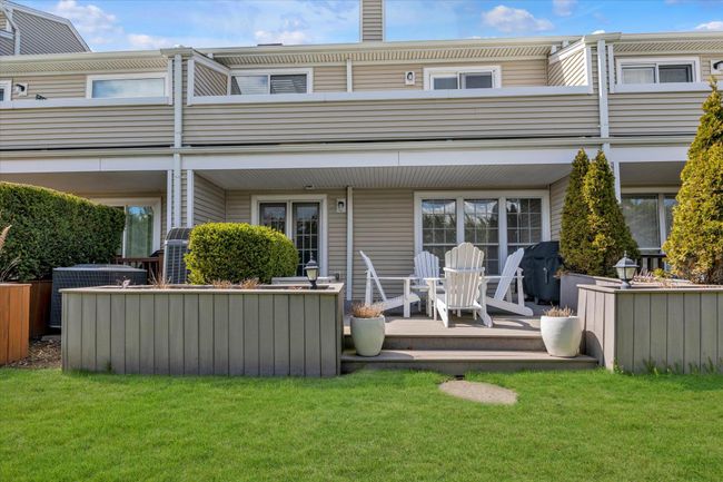 Back of house featuring a chimney, central air condition unit, a lawn, and a balcony | Image 19