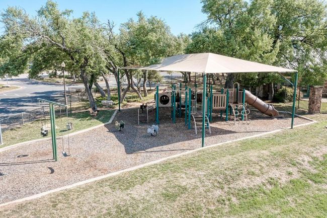 Communal playground featuring a yard and fence | Image 38