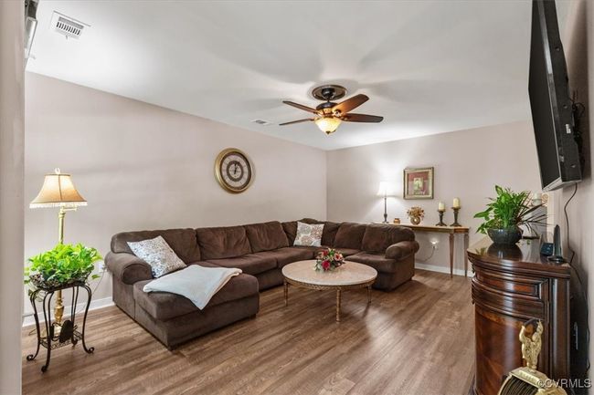 Living area featuring wood finished floors, baseboards, and a ceiling fan | Image 7