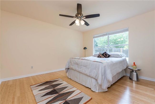 Bedroom with light wood-style floors and a ceiling fan | Image 8