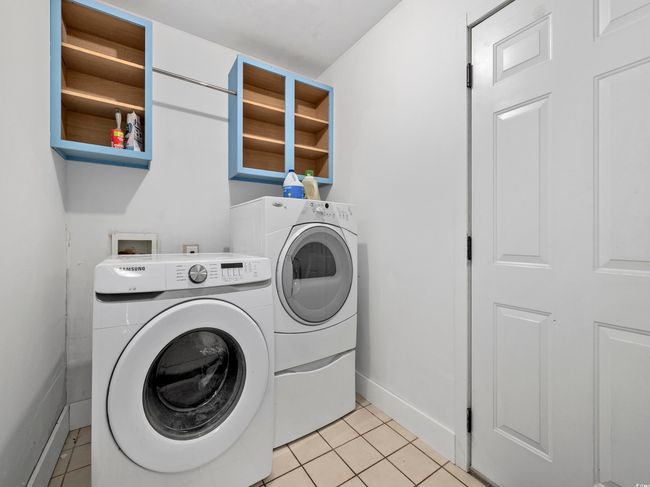 Laundry room with laundry area, baseboards, washing machine and dryer, and light tile patterned flooring | Image 24