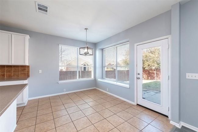 Unfurnished dining area with visible vents, a notable chandelier, baseboards, and light tile patterned floors | Image 24