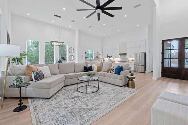 Living room featuring a wealth of natural light, a ceiling fan, and a towering ceiling | Image 7