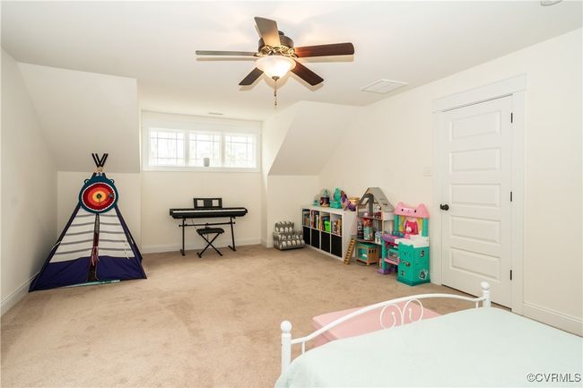 Bedroom featuring vaulted ceiling, a ceiling fan, baseboards, visible vents, and carpet | Image 23