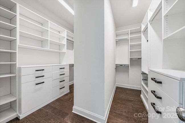 Customized closet system in the primary walk-in closet by Impact Fine Design | Image 20