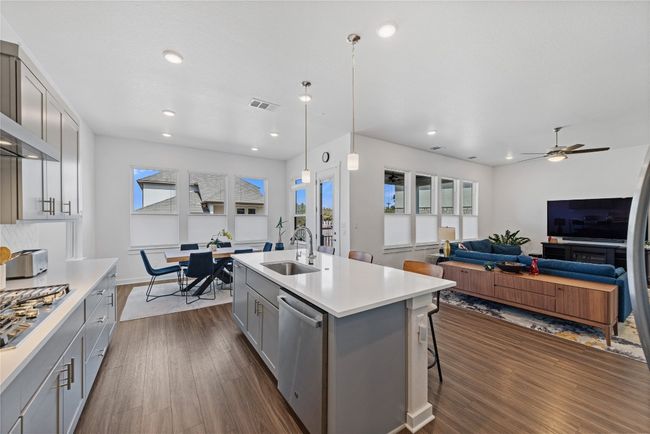 Kitchen with gray cabinets, a sink, dark wood-style floors, stainless steel appliances, and visible vents | Image 5