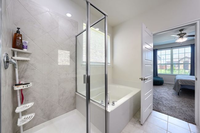 Bathroom with a shower stall, a garden tub, ensuite bath, tile patterned flooring, and a ceiling fan | Image 21