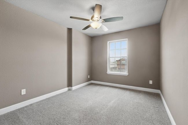 Unfurnished room with carpet flooring, ceiling fan, a textured ceiling, and baseboards | Image 28