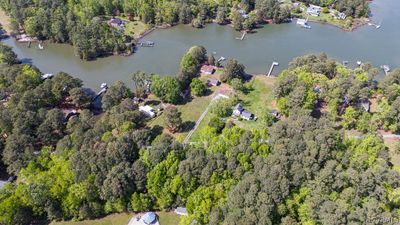 lot is in wooded area, just below white trailer on water | Image 1