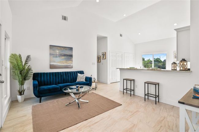 Bright and inviting living room with high ceilings, modern finishes, and abundant natural light, perfect for relaxation and entertaining. | Image 6