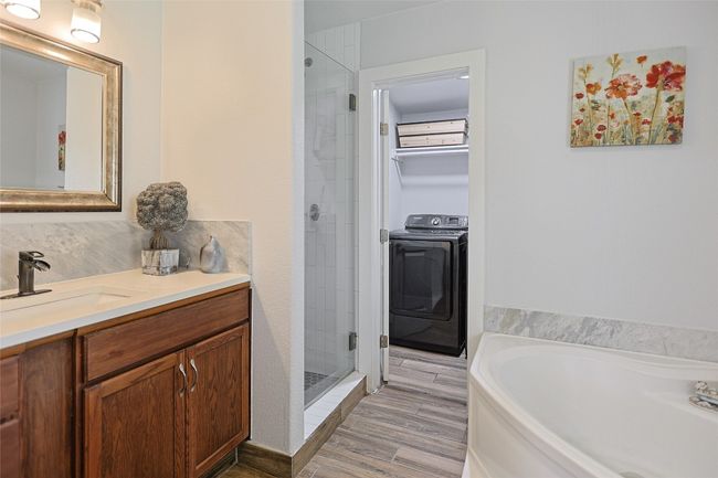 Bathroom with vanity, a garden tub, a stall shower, and wood finished floors | Image 18